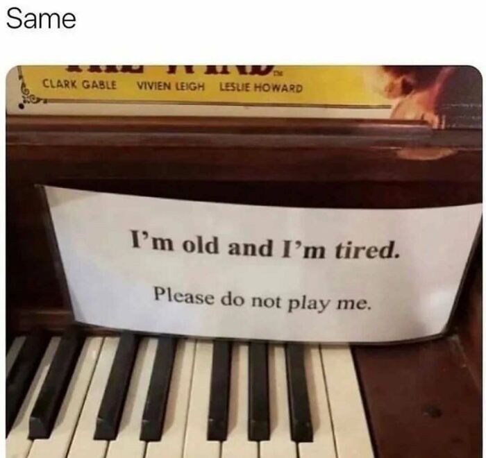 Piano with a sign reading "I'm old and I'm tired. Please do not play me," depicting a relatable mental health meme.