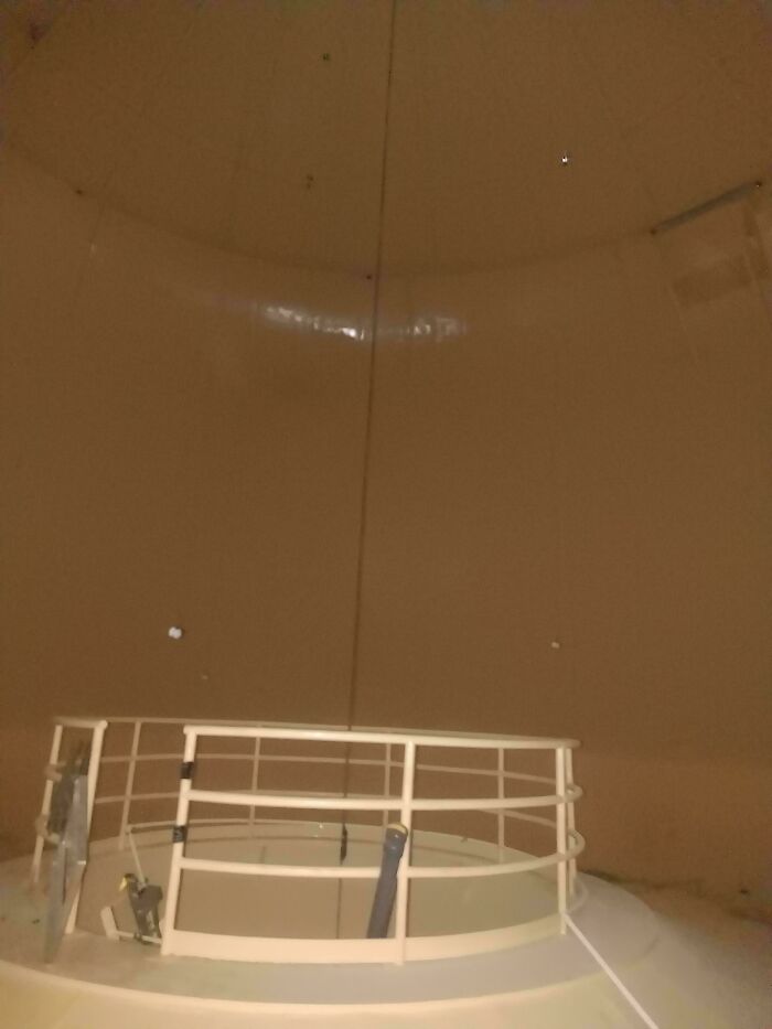 Fascinating image of an industrial tank interior, showcasing a circular safety railing and a vast, empty space inside.