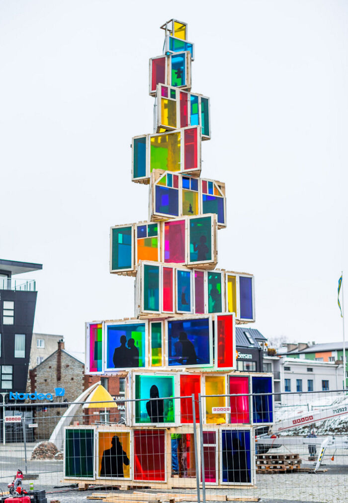 Colorful Christmas tree idea made from stacked, vibrant panels forming a unique outdoor display in an urban setting.