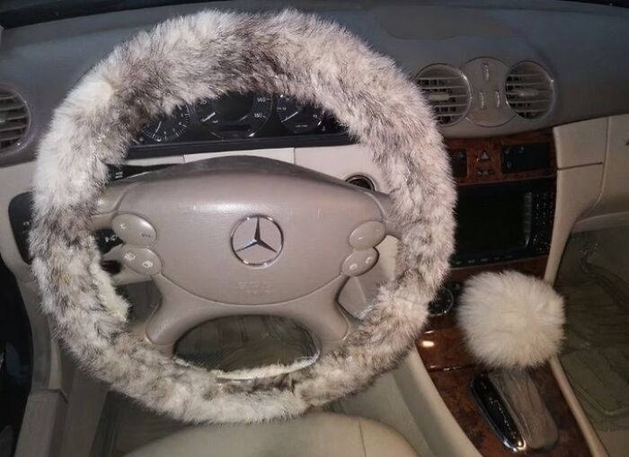 Furry steering wheel and gear shift cover in a Mercedes, showcasing an old internet feel.