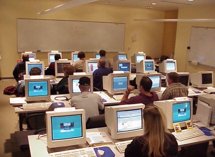 A classroom of people using old computers, capturing the essence of old-internet-feel pics.
