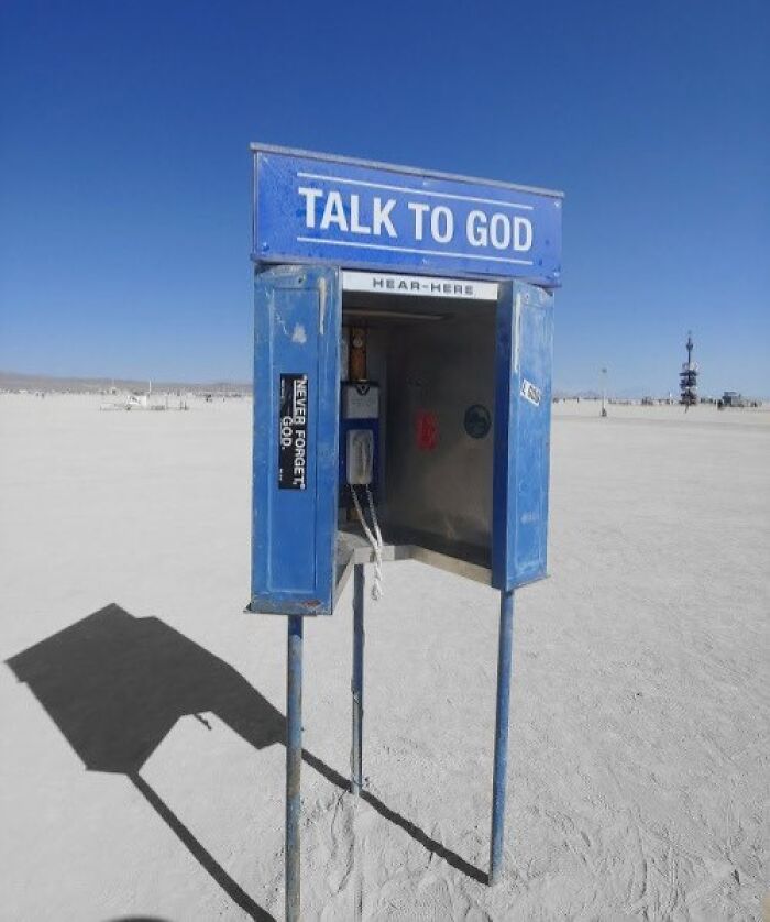 Old internet feel pic of a phone booth labeled “Talk to God” in a desert setting.