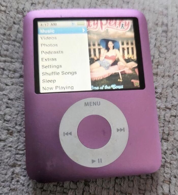 Purple iPod displaying music menu, evoking old internet feel.