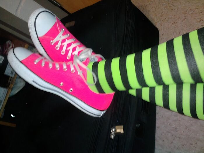 Bright pink sneakers with striped neon green and black socks evoke an old-internet feel.