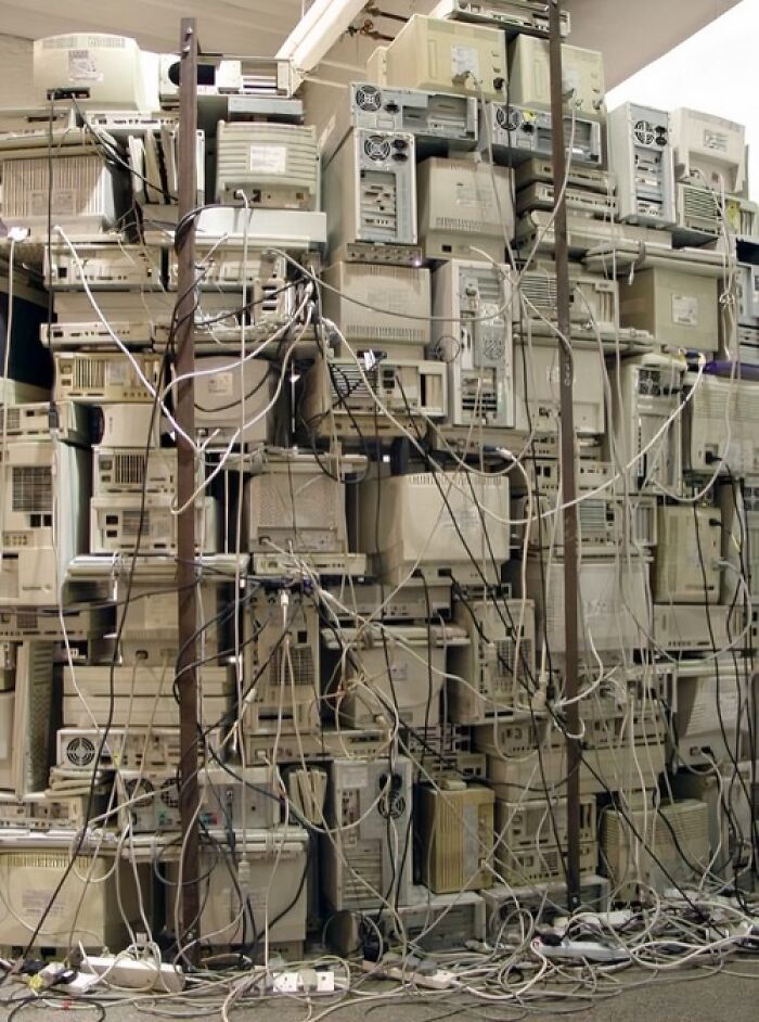 Stack of vintage computers and tangled wires creating an old-Internet-feel.