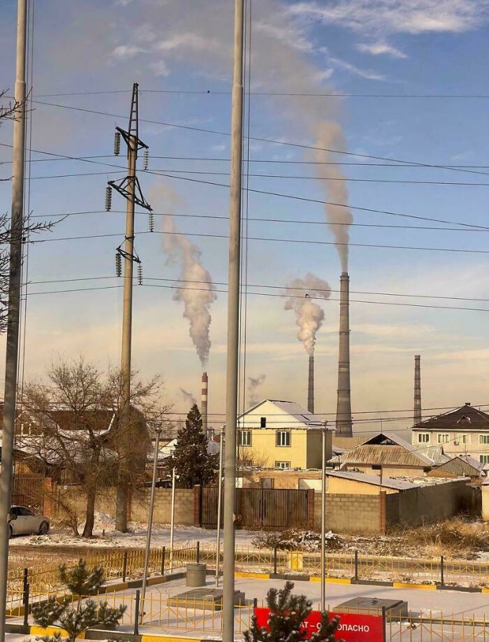 Industrial smokestacks in an urban area emitting pollution, exemplifying urban hell scenery.