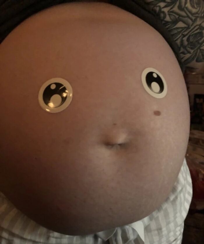 Pregnant belly with googly eyes creating a funny face, illustrating humorous pregnancy situations.