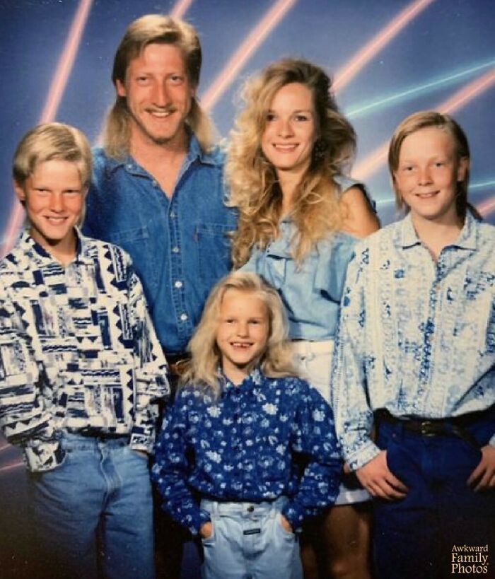Awkward family photo with retro outfits and neon laser background, capturing a vintage family moment.