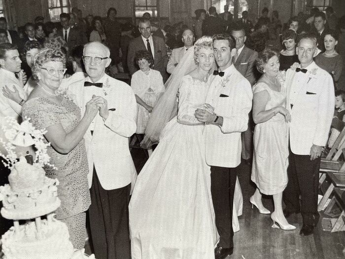 60s fashion looks at a wedding with couples dancing, featuring classic suits and a bridal gown.