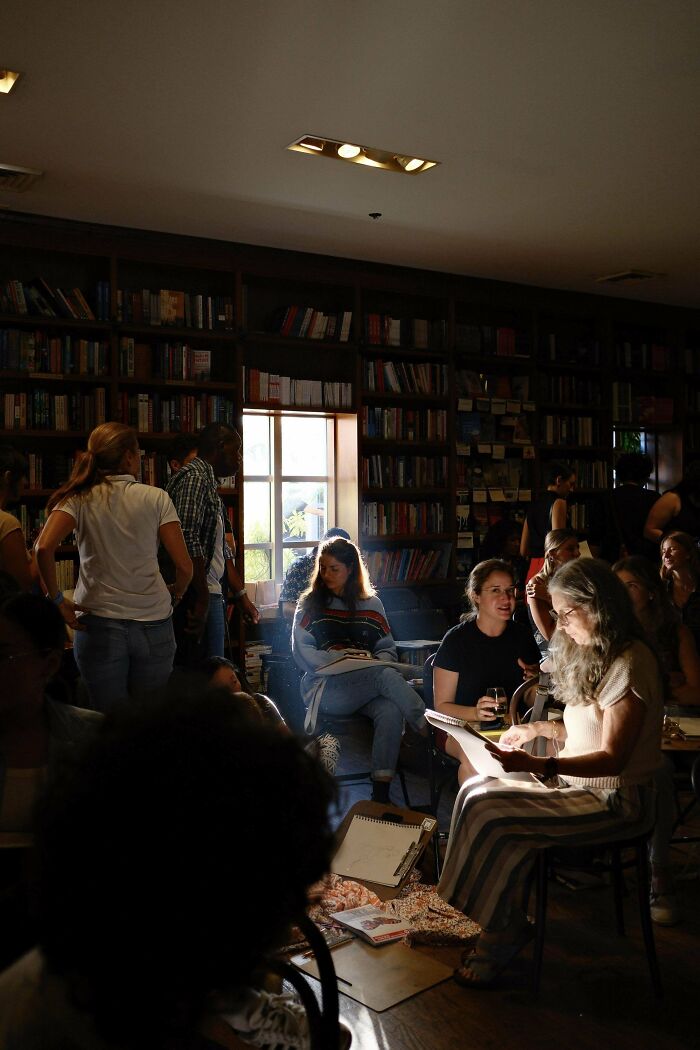 Creative street photography capturing a lively social scene in a cozy library setting with people reading and interacting.
