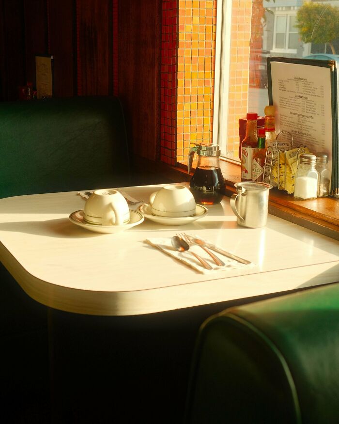 Sunlit diner table with cups and condiments, capturing creative street photography essence.
