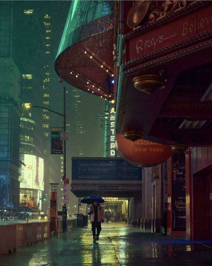 Person walking with umbrella on a rainy night in city, capturing creative-street-photography elements with neon signs and reflections.