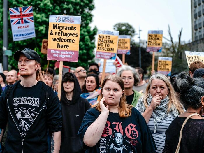 Protesters holding signs against racism in a creative street photography scene.