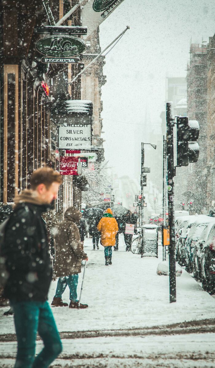 Snowy city scene with pedestrians in winter coats, demonstrating creative street photography.