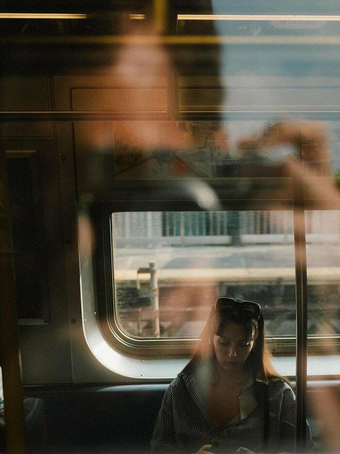 A reflective moment on a train captures the essence of creative street photography.