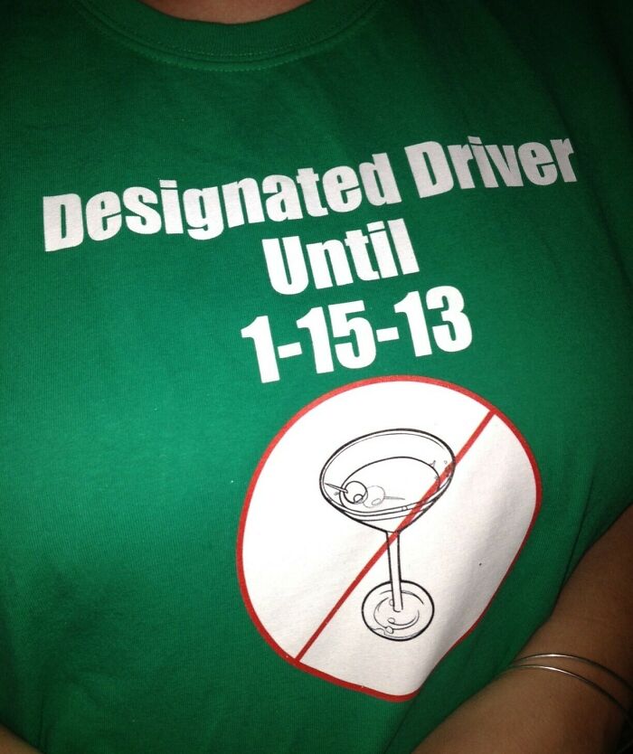 Green T-shirt with "Designated Driver Until 1-15-13" text, illustrating funny pregnancy situation.