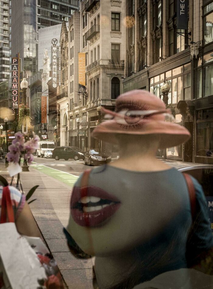 Creative-Street-Photography: Reflections blend a city street scene with a woman's portrait, creating a surreal urban composition.