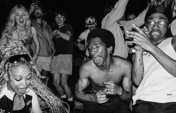 Diverse group enjoying a nighttime street event, embodying creative street photography dynamics and emotions.