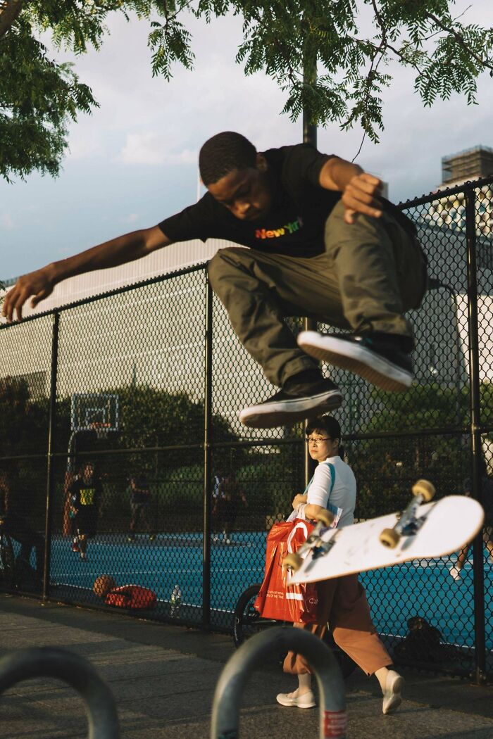 Skateboarder performing a jump in an urban setting, capturing a moment in creative street photography.