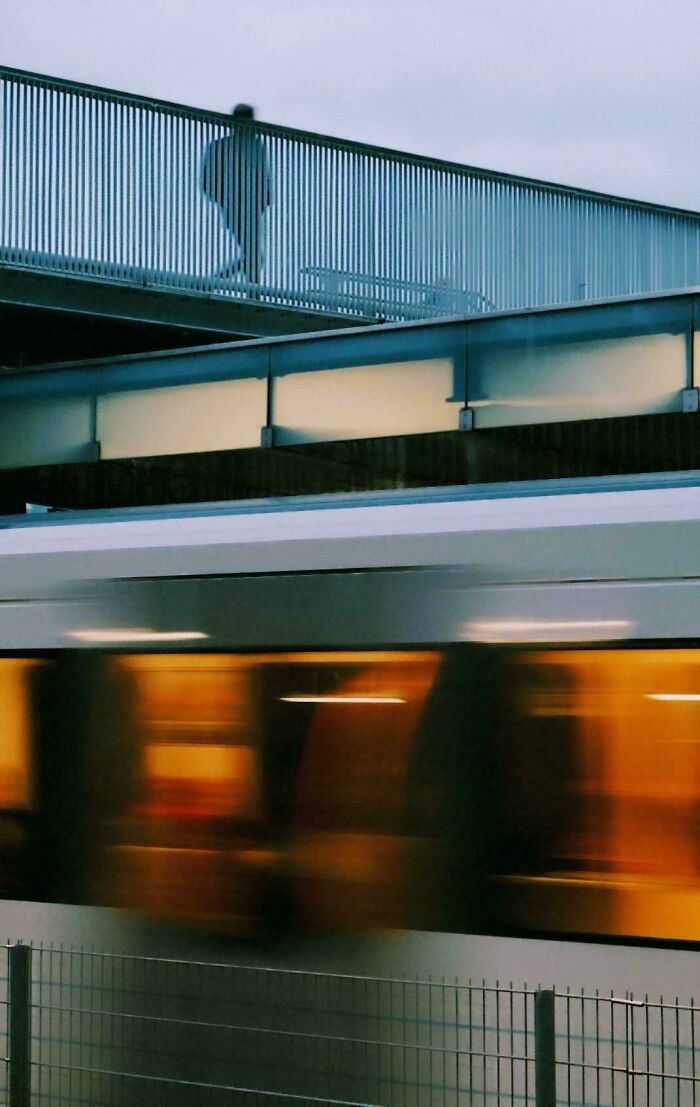 A fast-moving train with blurred motion in an urban setting, capturing creative street photography.