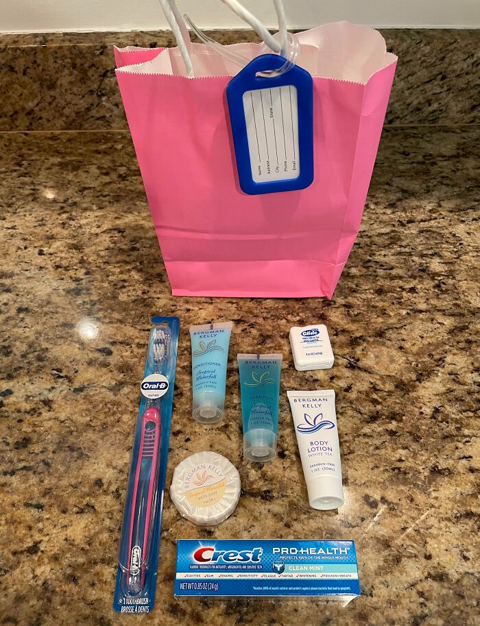 Pink gift bag with toiletries laid out: toothbrush, toothpaste, lotion, and soap; example of disappointing presents gifts.
