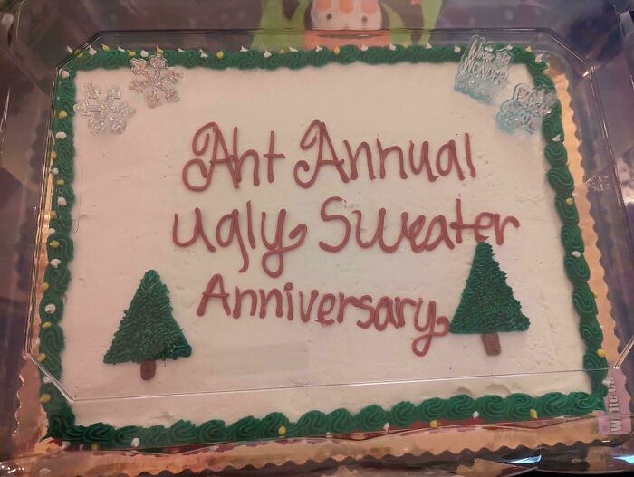 Christmas accident: cake with misspelled "Anh Annual Ugly Sweater Anniversary" message, decorated with trees and snowflakes.