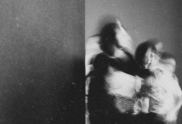 Blurred figures in black and white, capturing creative street photography with a dynamic, artistic style.