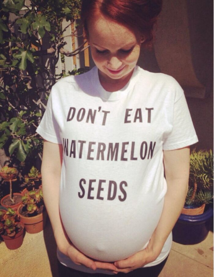 Pregnant woman in humorous shirt reading "Don't Eat Watermelon Seeds," showcasing funny pregnancy situations.