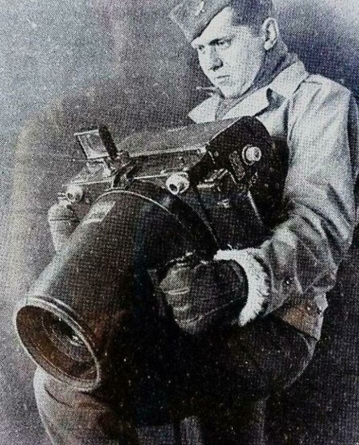 A man holding a large, unusual camera-like device; an example of strange inventions.