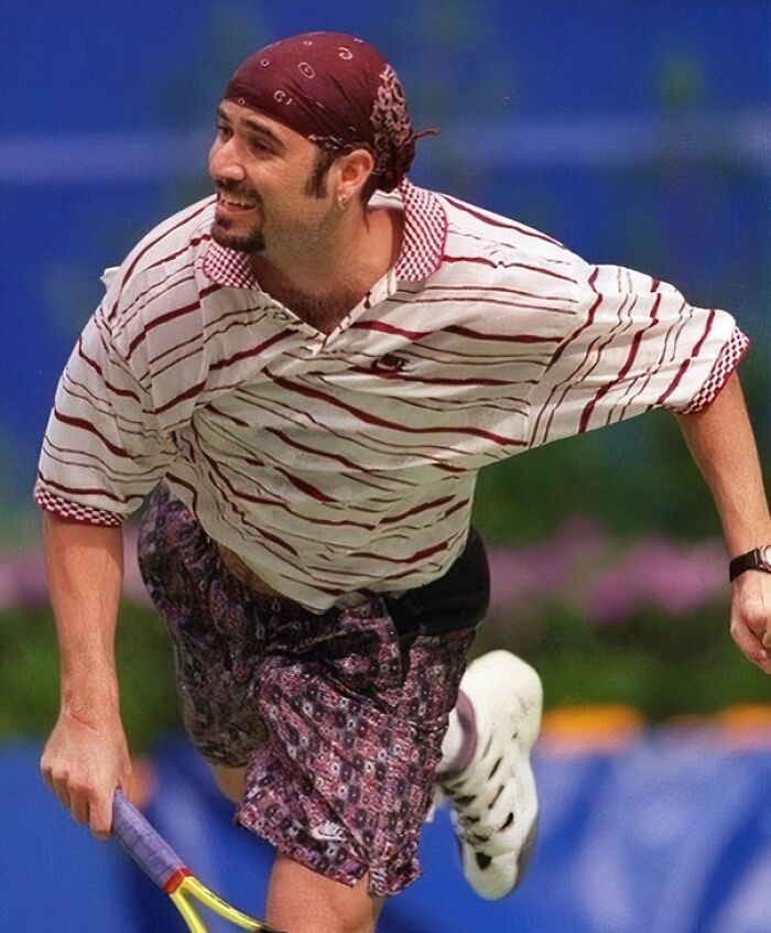 Tennis player in 90s fashion with striped shirt and bandana, embodying nineties style and energy on the court.