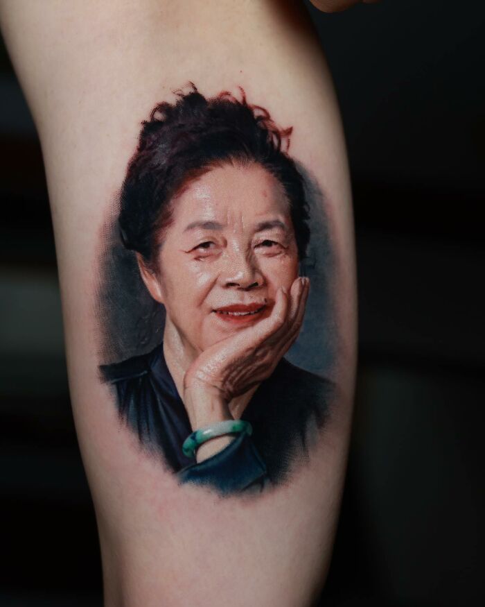 Realism tattoo of a smiling elderly woman, showcasing ink mastery and illusion.