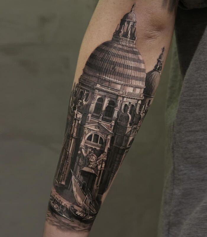 Realistic tattoo of a detailed architectural design on an arm, showcasing mastery in ink and illusion.
