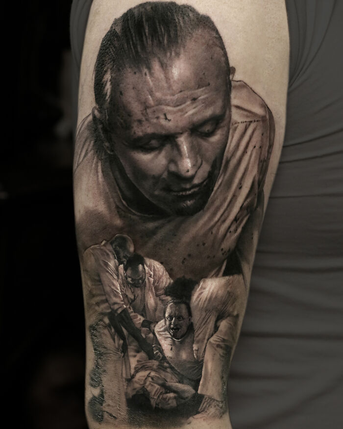 Realistic tattoo art on an arm, showcasing detailed black and gray portraiture by Victoria Lee.