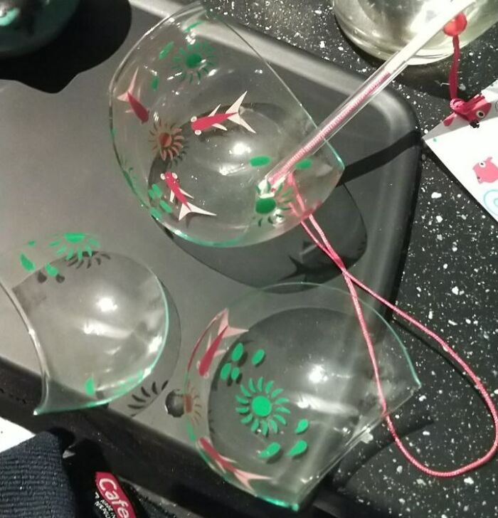 Broken Christmas ornament with colorful patterns on a black tray, illustrating holiday accidents.