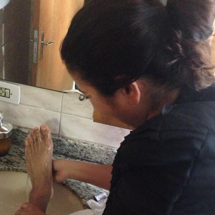 Person using a sink to wash a foot in a humorous and bizarre scenario, showcasing funny social media moments.