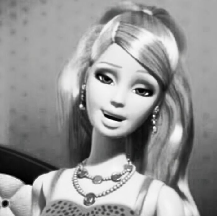 A Barbie doll in grayscale, smiling with flowing hair and jewelry, reflecting funny and bizarre social media post content.