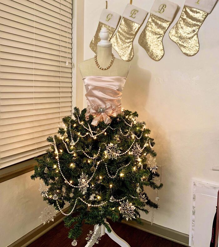 Mannequin dressed as a Christmas tree with lights and ornaments, showcasing creative Christmas tree idea.
