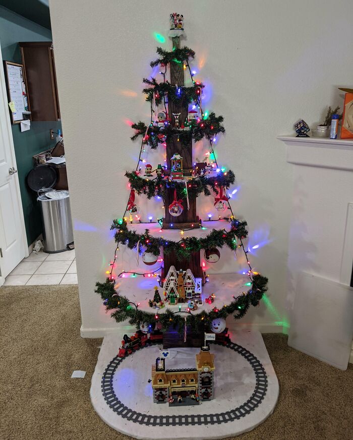 Creative Christmas tree idea with colorful lights and miniature village decoration.