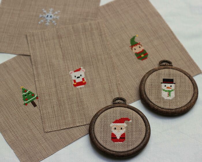 Creative DIY Christmas decorations with cross-stitched Santa, snowman, and elf on fabric and in frames.