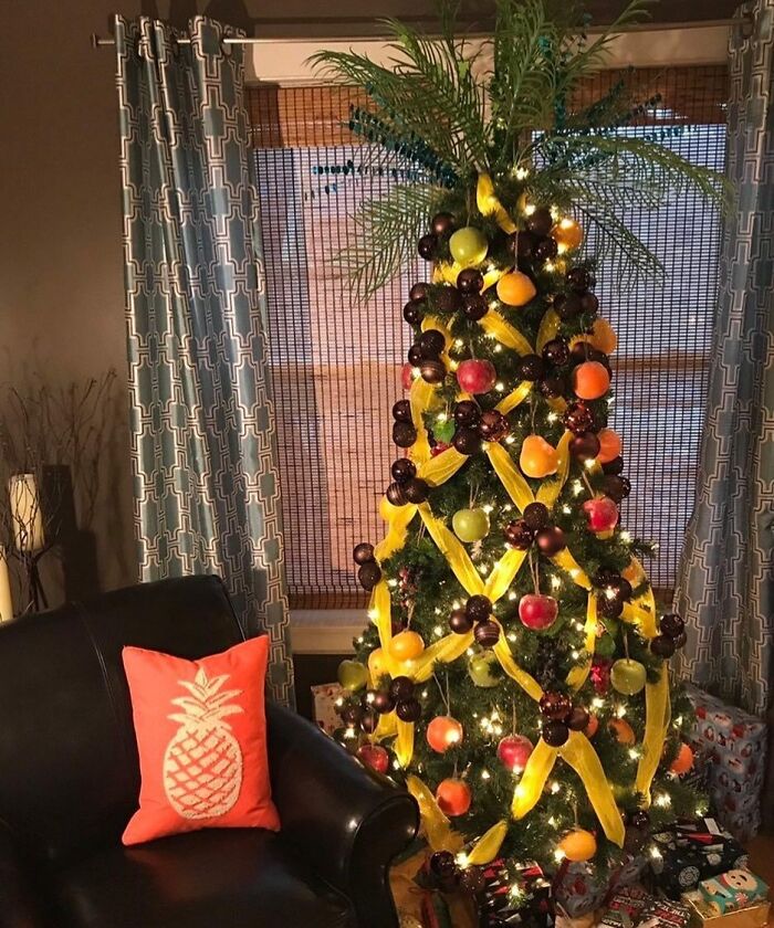 Unique Christmas tree idea decorated with vibrant fruits and yellow ribbons in a cozy living room setting.
