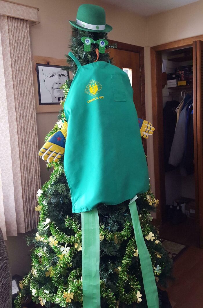 Creative Christmas tree decor with a green apron, hat, and colorful gloves.