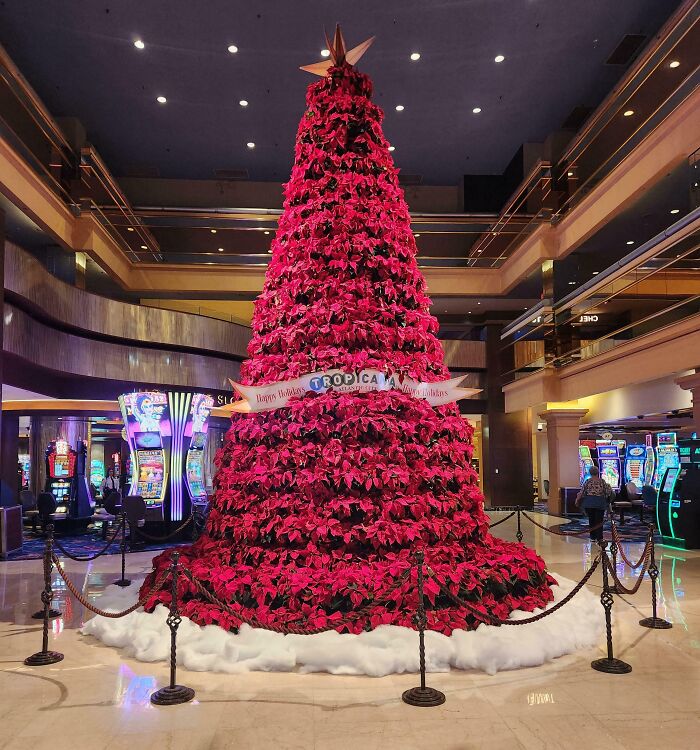 Festive Christmas tree idea with vibrant red poinsettias displayed in a luxurious casino setting.