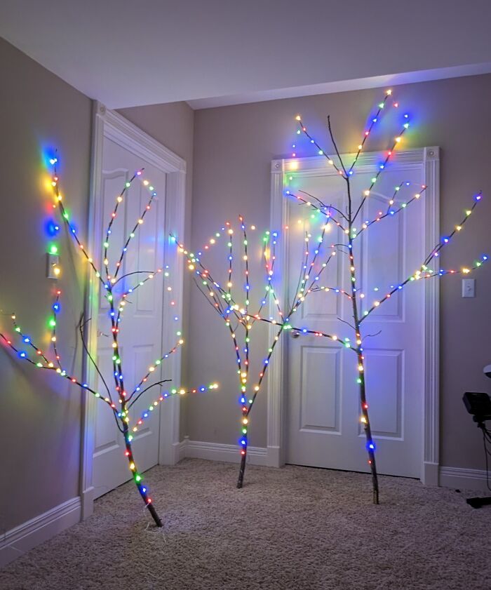 DIY Christmas decorations using branches adorned with colorful lights.