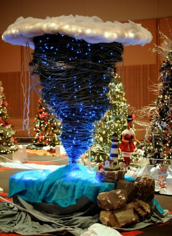 Creative Christmas tree idea with tornado shape, wrapped in blue lights, surrounded by other Christmas decorations.