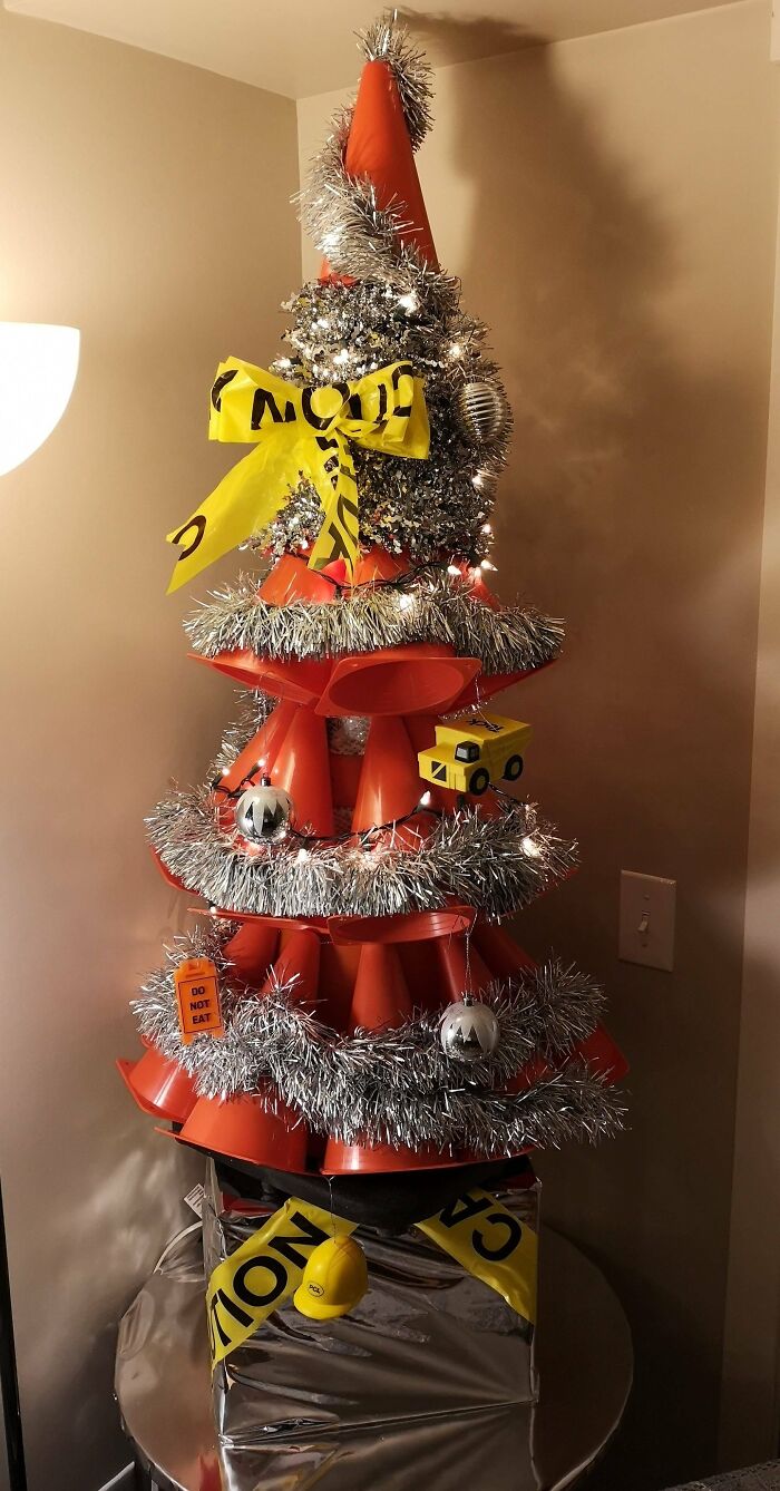 Creative Christmas tree made from traffic cones, tinsel, and caution tape decorations.