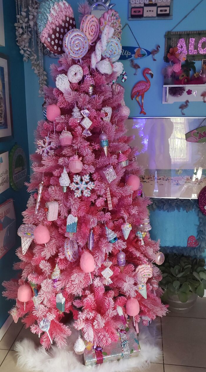 Pink Christmas tree decorated with candy-themed ornaments.