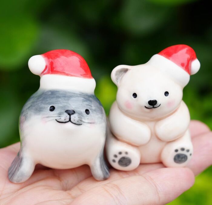 Cute DIY Christmas decorations featuring a seal and bear figurine with Santa hats on a hand.