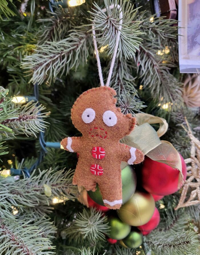 Gingerbread man felt ornament hanging on a Christmas tree, part of creative DIY Christmas decorations.
