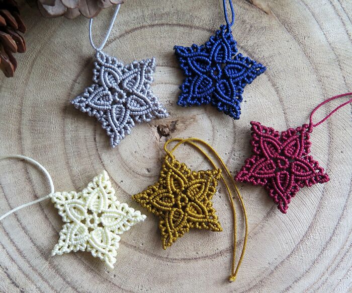 Handmade star ornaments on wood slice, showcasing creative DIY Christmas decorations in various colors.