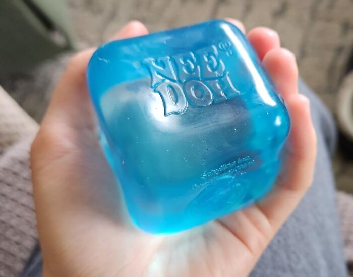 Blue Nee Doh stress ball in hand, ideal gift for antisocial people.